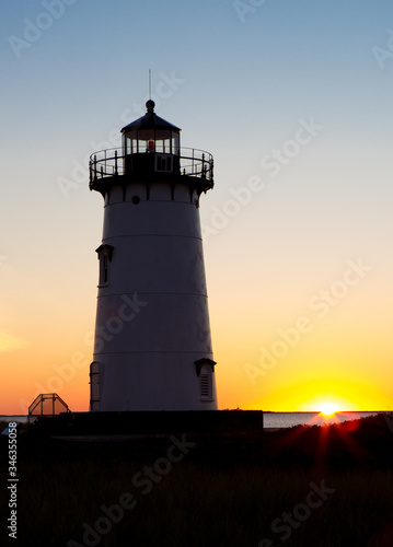 Sun peaks over the horizon at Edgartown Lighthouse in Marth's Vineyard