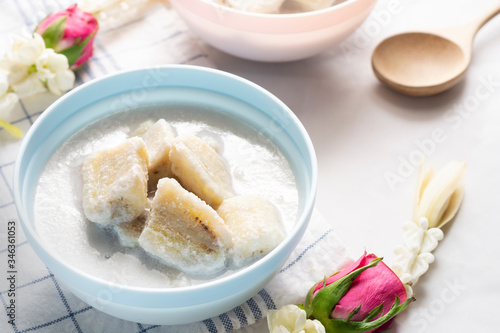 Banana in coconut milk on a vintage blue cup and white cloth background. Traditional sweet dessert of asian, Thailand.