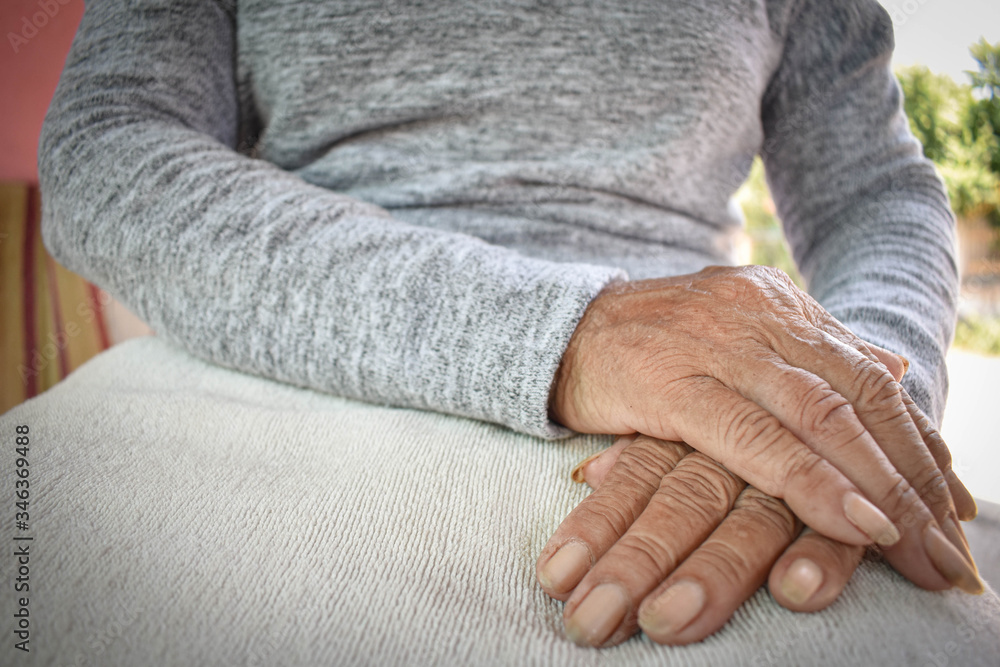 Hand of an old woman withering on his lap