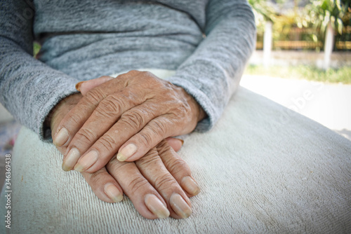 Hand of an old woman withering on his lap