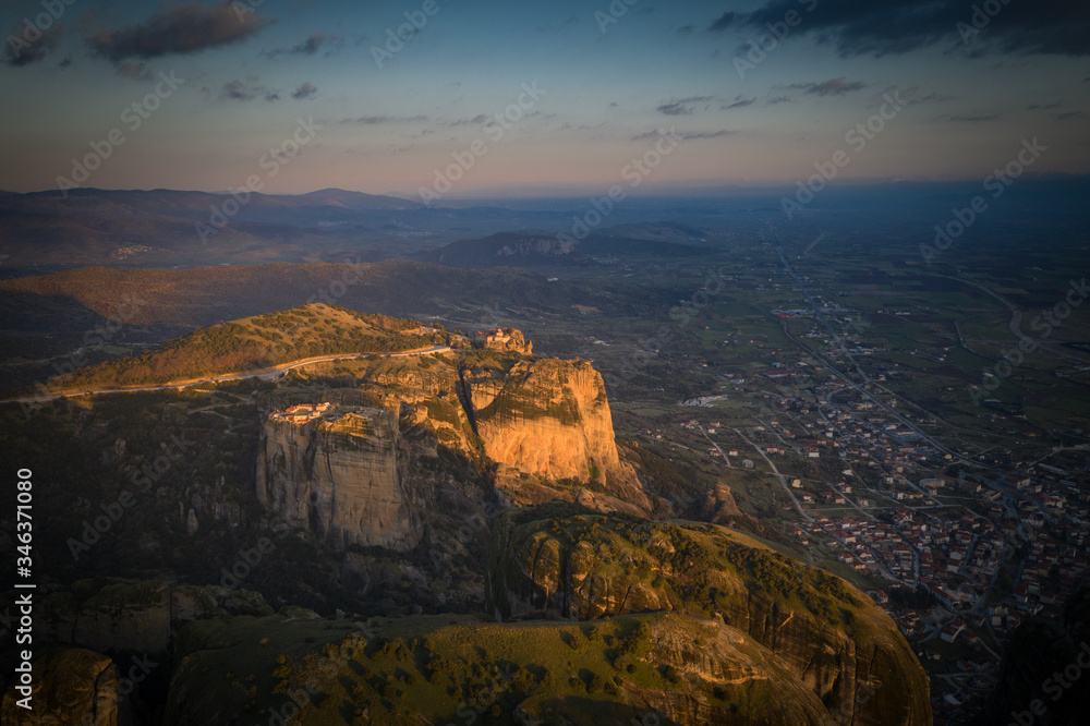 Mysterious hanging over rocks monasteries of Meteora, Greece at sunrise time