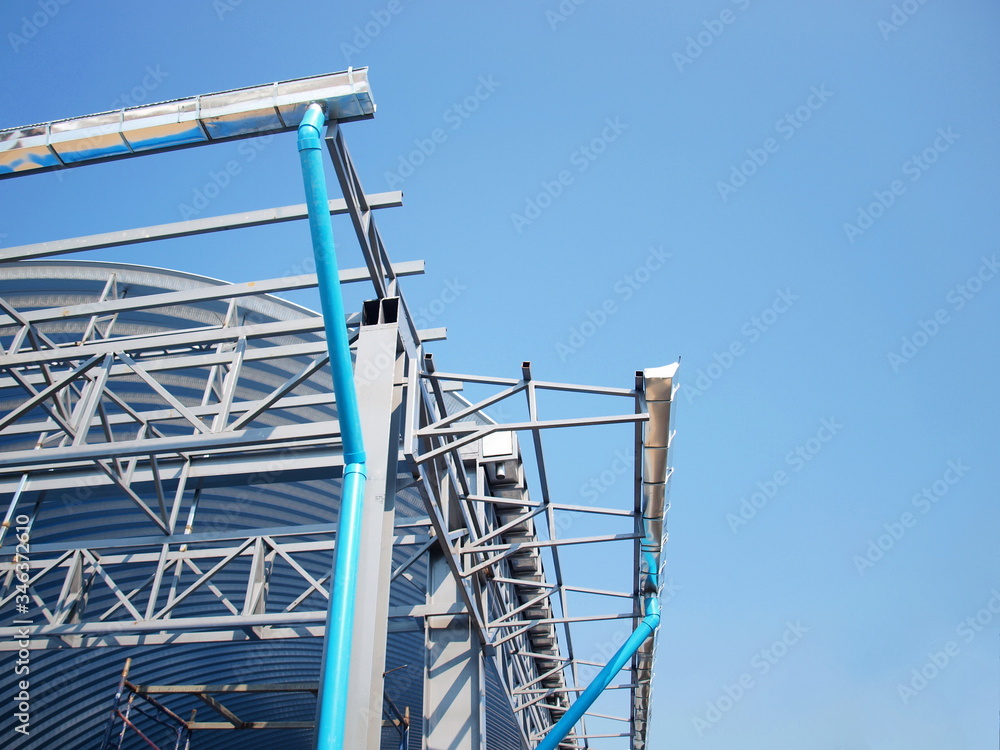 Pipes and rainwater gutters with metal frames on the dome being built On the blue sky background. Selective focus Pipes and rainwater gutters with metal frames on the dome being built On the blue sky background. Selective focus