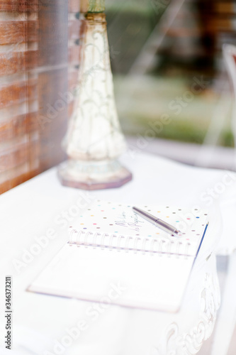 White desk with a lamp, a stylograph pen and a diary