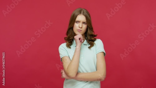 Need to think! Pensive doubting woman in polo t-shirt pondering and imagining in mind, wondering difficult solution, feeling confused, not sure about choice. studio shot isolated on red background