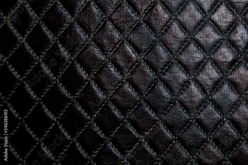 Artificial leather of dark brown color. Faux leather texture with a diamond pattern.