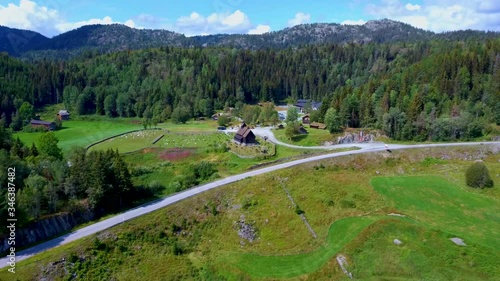 Aerial drone view of famous Eidsborg Stave Church, Norway. A old wooden church is surrounded by a cemetery, green meadows, a lake and mountainous forest. Shot in the summer photo