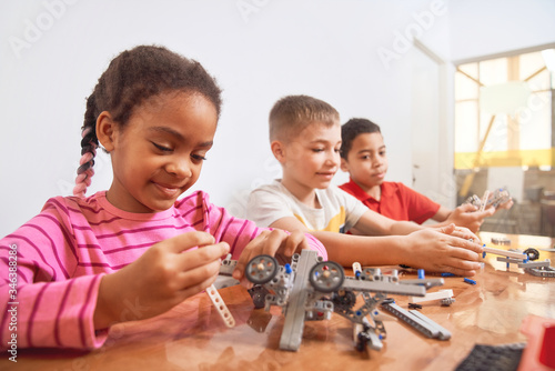 Multiracial kids using building kit.