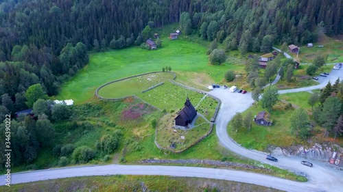 Aerial drone view of famous Eidsborg Stave Church, Norway. A old wooden church is surrounded by a cemetery, green meadows, a lake and mountainous forest. Shot in the summer photo