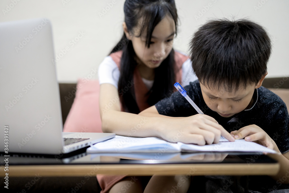 Little brother studying with big sister at home,teenager girl is teaching,helping and child boy learning,kindergarten student doing school homework,kid writing a book,development,family education Little brother studying with big sister at home,teenager girl is teaching,helping and child boy learning,kindergarten student doing school homework,kid writing a book,development,family education