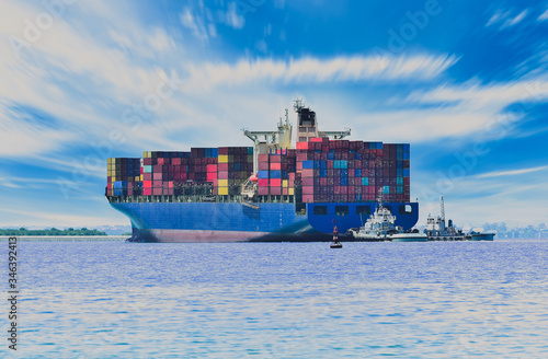 Logistics and international shipping containers, cargo vessels and air planes blue sky, ocean freight transportation and tug boat assistance stern ship.