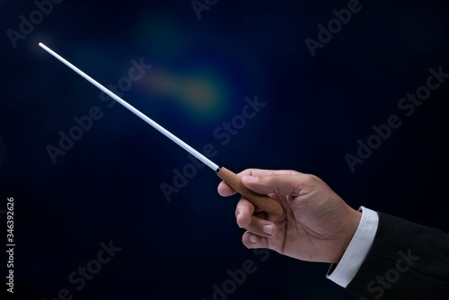 Orchestra conductor hands baton. Hands of conductor holding stick on a black background 