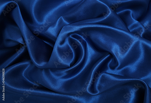 Smooth elegant blue silk or satin luxury cloth texture as abstract background. Luxurious Christmas background or New Year background design