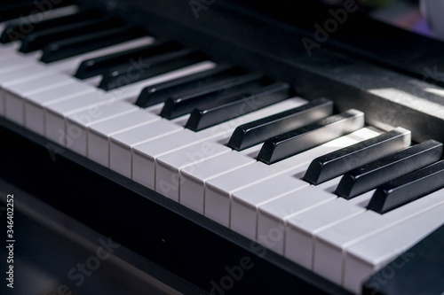 closeup side view of piano keyboard with low light