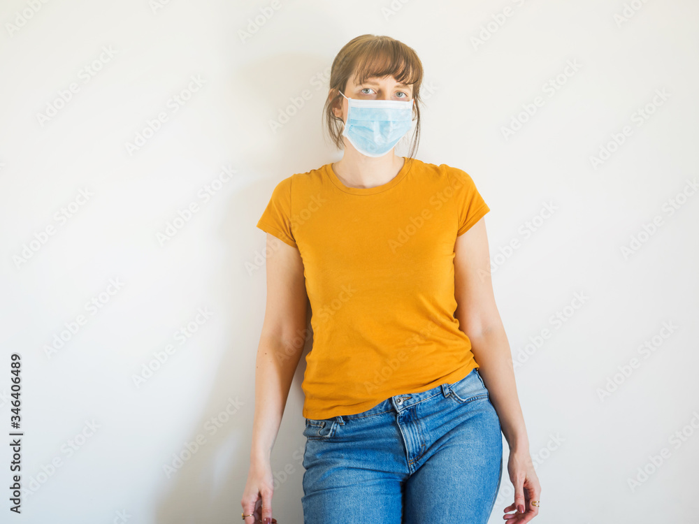 Young caucasian woman in yellow T-shirt wearing protective face mask to face virus spreading or pollution. Young caucasian woman in yellow T-shirt wearing protective face mask to face virus spreading or pollution.