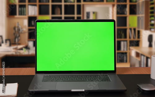 Laptop computer with Green screen Mock-up on working desk in office with no people