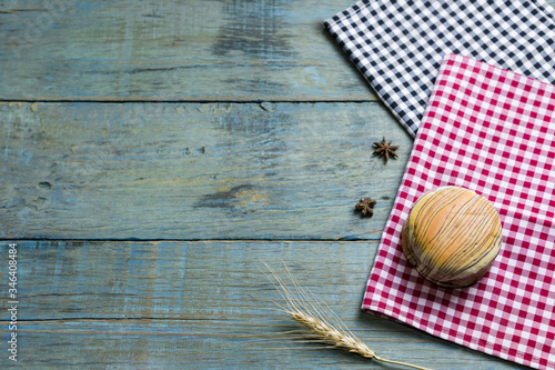 fresh bread put on red.scottish pattern fabric with grains on old wooden table background.Top view with copy space and selective focus.