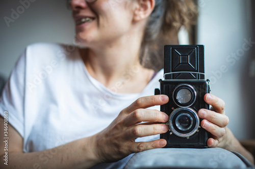 Photographer prepares her vintage analog medium format camera. 