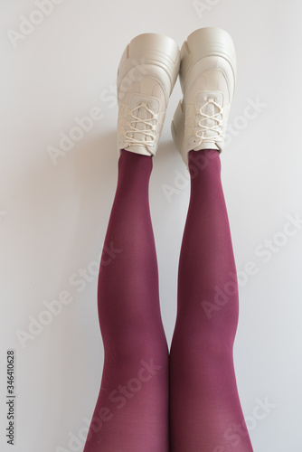 Legs looking up in red tights. Platform shoes, fashionable modern shoes. Trend.