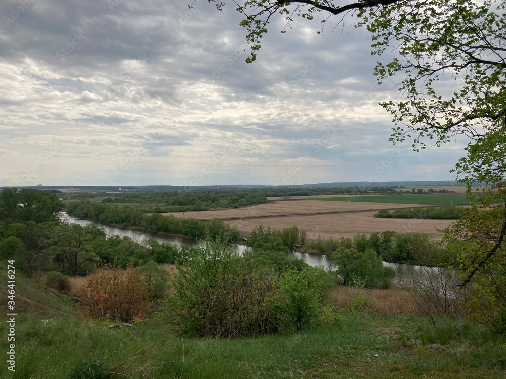 lake in countryside on cloudy day. Bird's eye view of lake stretches in length in rural area. lake in countryside on cloudy day. Bird's eye view of lake stretches in length in rural area.