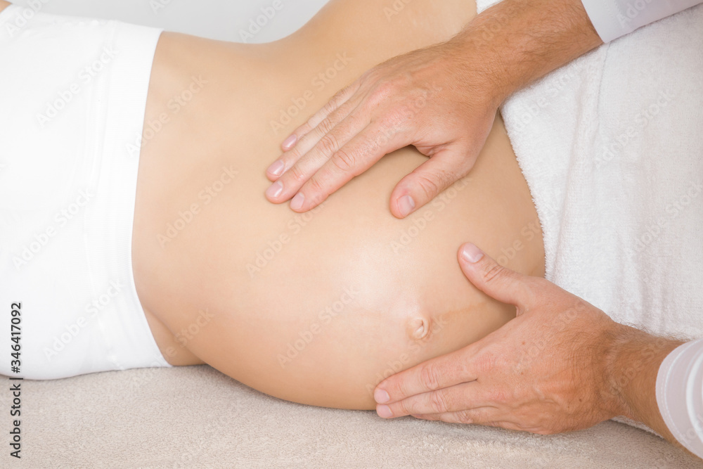 Young man hands touching pregnant woman belly. Lying down on bed. Body health in pregnancy time. 9 month. Relaxing day. Close up.