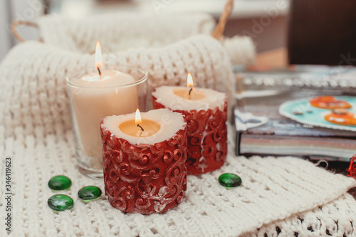 aroma candles on the table, knitted clothes and home comfort