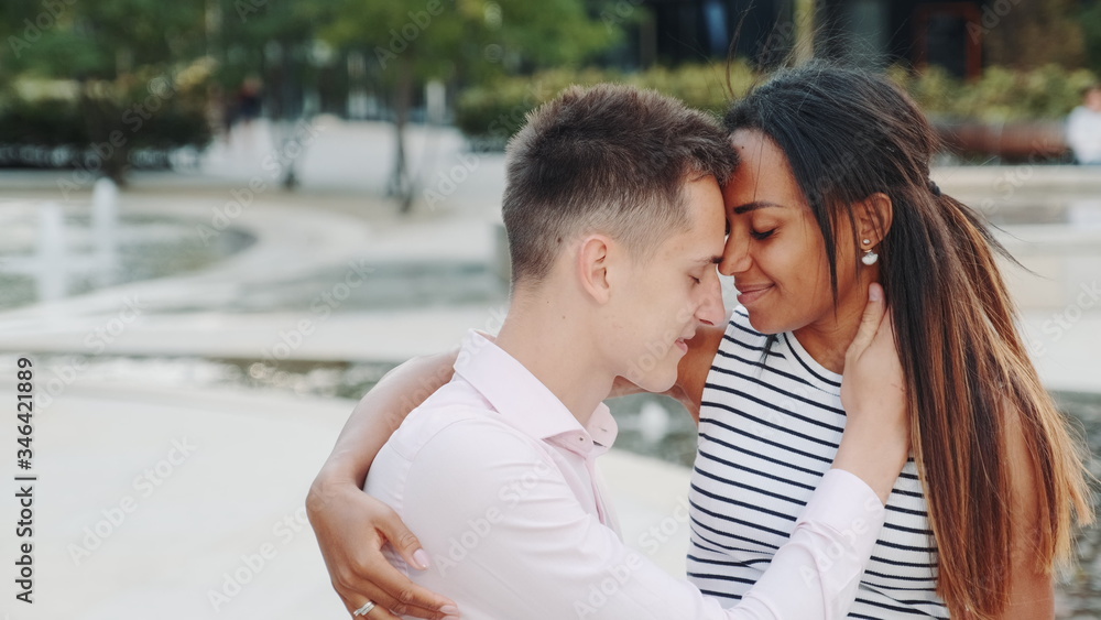 Happy multiethnic couple having romantic date in a beautiful place outdoors. Relationship concept. Happy multiethnic couple having romantic date in a beautiful place outdoors. Relationship concept.