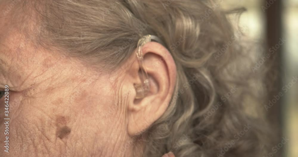 close - up of an elderly woman's ear with a hearing aid. close - up of an elderly woman's ear with a hearing aid.