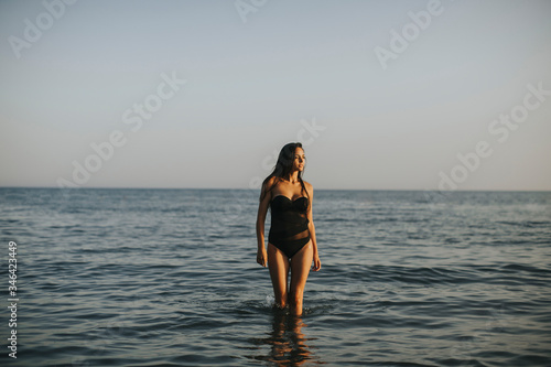 Young woman walking in water at the beach