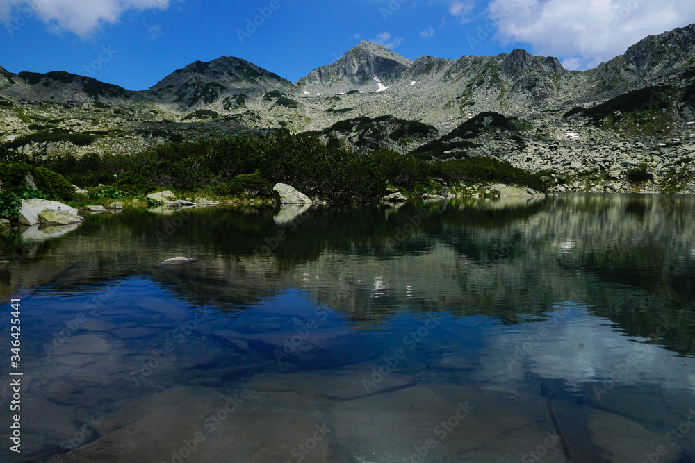Reflection of rocky peaks in Georgiyski lakes near Sinanitsa in Pirin mountain National park in Bulgaria
