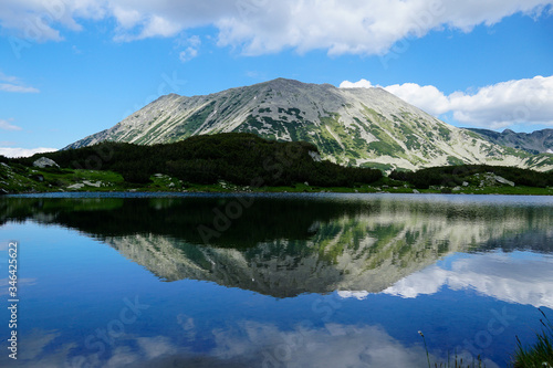 Reflection of rocky Todorka peak in the calm water of Muratovo lakes in Pirin mountain National park in Bulgaria  © emil