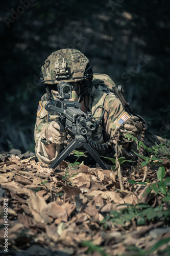 soldier with a rifle.Army soldier in protective uniform holding rifle .special forces soldier assault rifle with silencer. Sniper in the forest. 