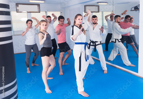  adults attempting to master new moves during karate class