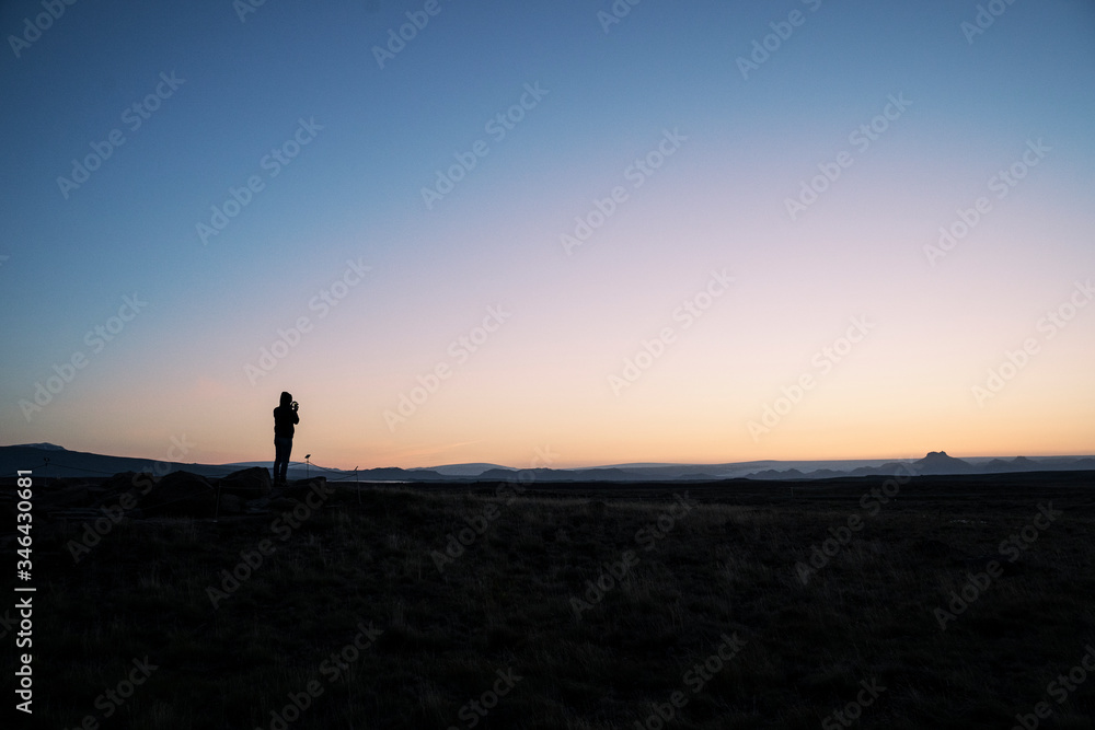 Silhouette of a person taking a photo of the horizon