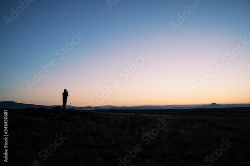 Silhouette of a person taking a photo of the horizon