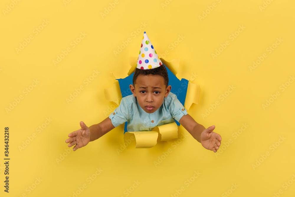 Nervous and sad birthday boy African American on torn paper yellow