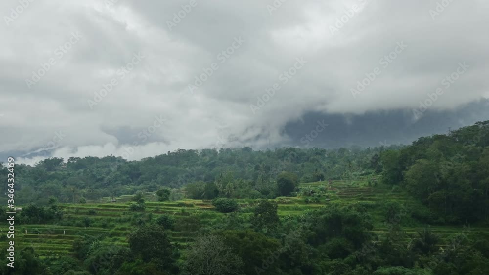 Fog rises from rice fields located terraces. Rain clouds move on the tops of mountains. Rainy season. Bali. Indonesia. Time lapse Dolly zoom Fog rises from rice fields located terraces. Rain clouds move on the tops of mountains. Rainy season. Bali. Indonesia. Time lapse Dolly zoom