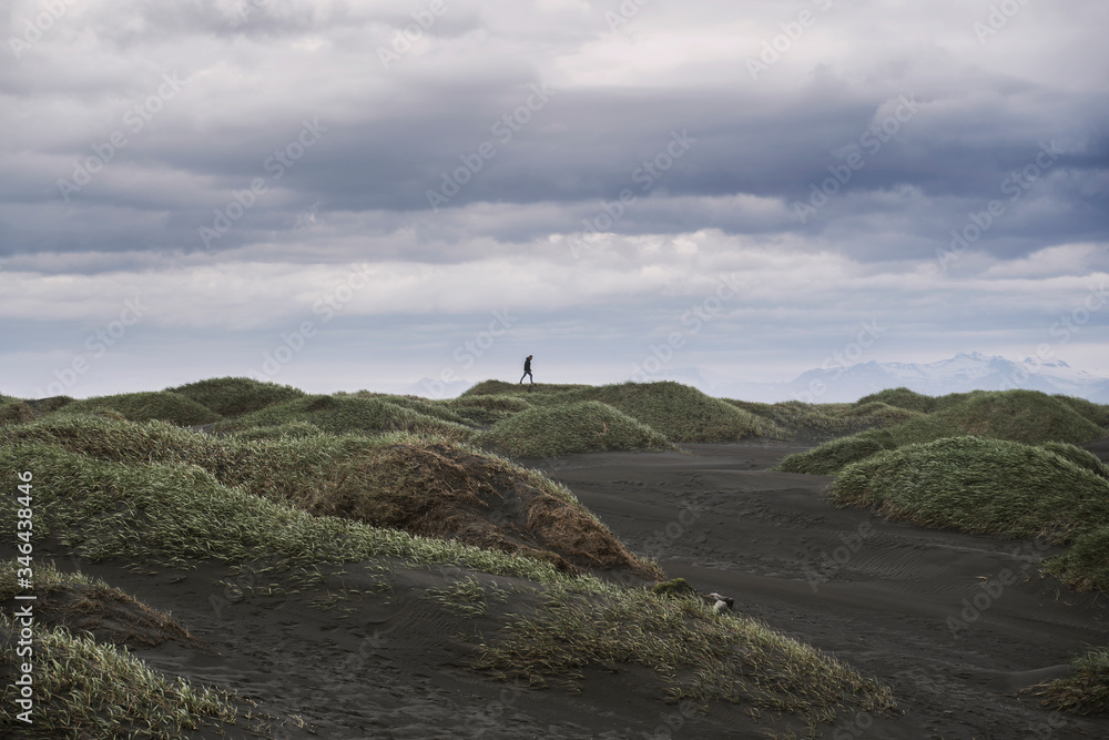 Lone person walking in dunes far away Lone person walking in dunes far away