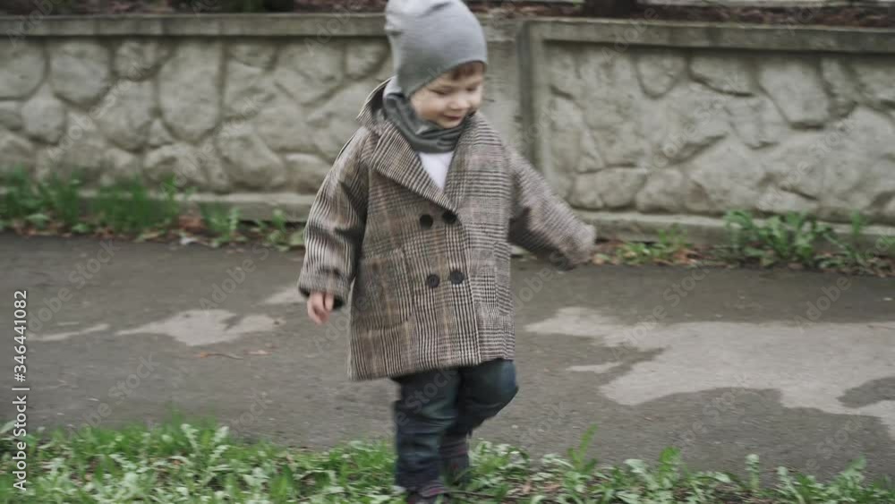 Boy child in a coat in the alley Boy child in a coat in the alley