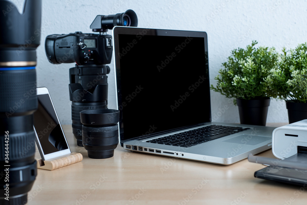 Naklejka premium Photographer's desk with lenses, laptop, phone, photo printer on a neutral background.