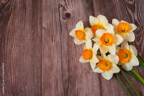 Flower composition. Beautiful bouquet of bright spring daffodils close-up on a wooden background. Selective focus. Free space.