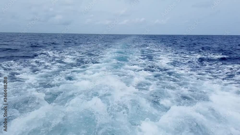 water splashes on the back of the boat while sailing on seawater on a cloudy day in Maldives water splashes on the back of the boat while sailing on seawater on a cloudy day in Maldives