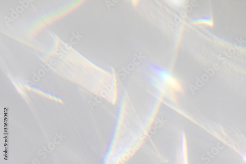 Blurred water texture overlay effect for photo and mockups. Organic drop diagonal shadow caustic effect with rainbow refraction of light on a white wall. Shadows for natural light effects