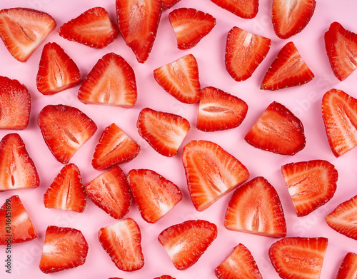 Sliced strawberry on mild pink paper background 
