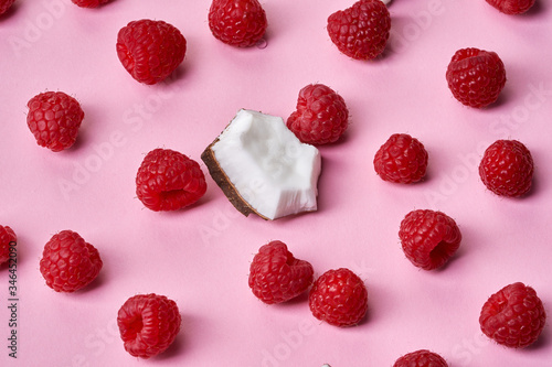 Raspberries with coconut piece on pink background