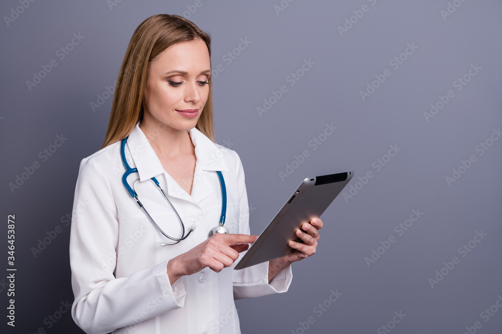 Close-up portrait of nice attractive focused blonde girl doc therapist medical using gadget web wireless connection searching information remote isolated over grey violet pastel color background Close-up portrait of nice attractive focused blonde girl doc therapist medical using gadget web wireless connection searching information remote isolated over grey violet pastel color background
