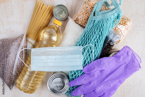 long-term storage products and protective equipment prepared for delivery due to quarantine on a light wooden background