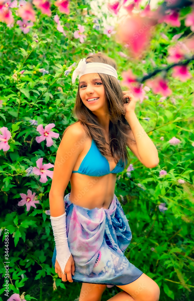 Model looking Girl standing in a swimsuit on the background of green grass and forest. Model looking Girl standing in a swimsuit on the background of green grass and forest.