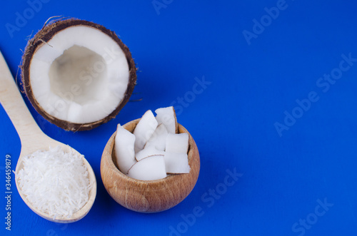 Natural coconut milk, coconut shavings, coconut chips on a blue background. The concept of healthy food.