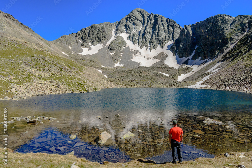 Hiker enjoying beautiful views  at the lake (view of the Peak of Infern, in the Catalan Pyrenees Mountains (Spain)