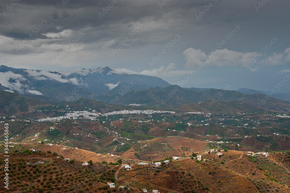 Storm clouds surrounding The Moorish village of Frigiliana nestling in the mountains, Costa del Sol, Andalucia, Spain